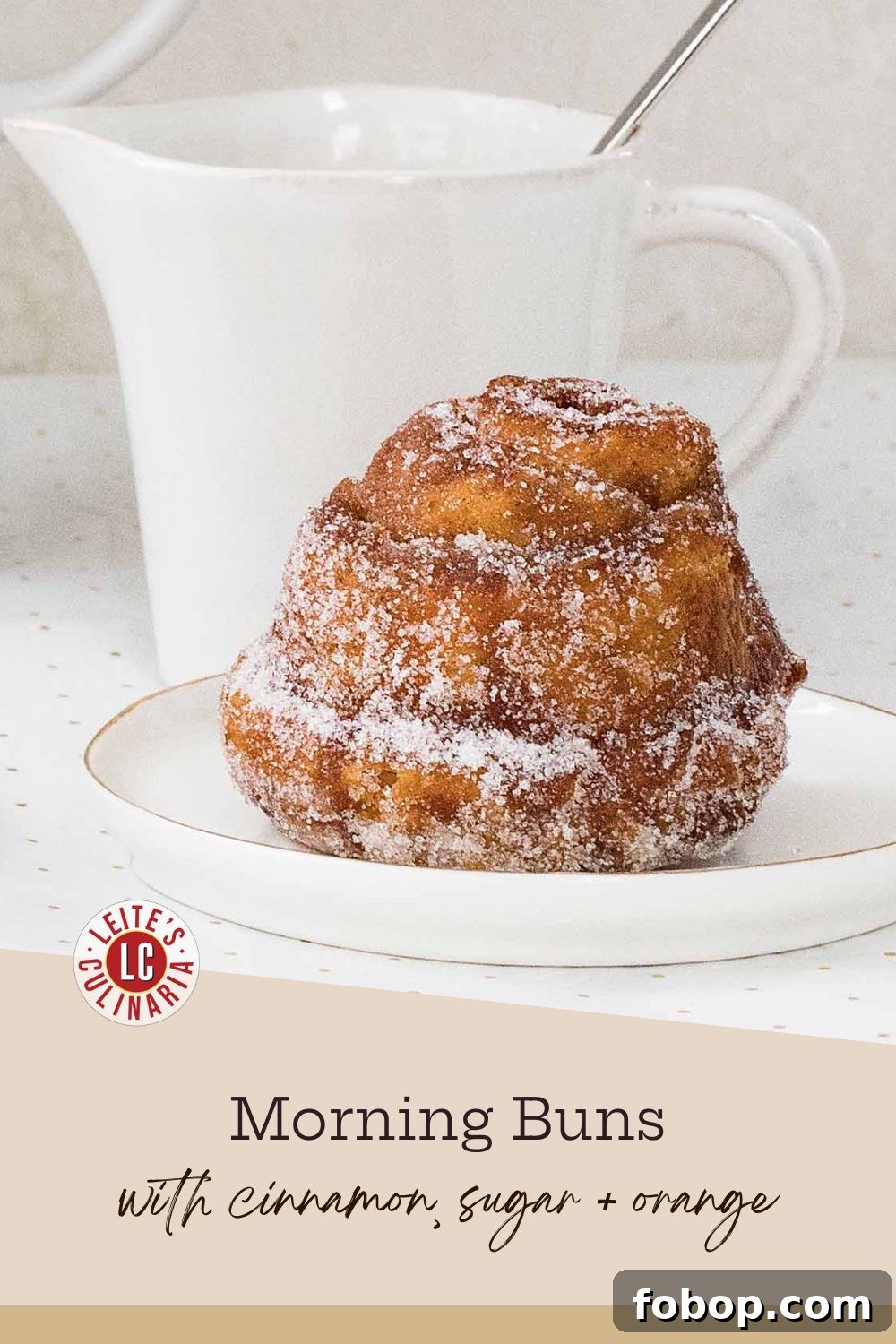 Perfectly Flaky Morning Buns: Cinnamon Sugar Pastry Recipe 3 A fluffy, sugar-coated morning bun sits on a small white plate with a gold rim.