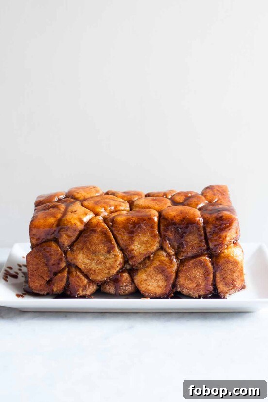 Perfectly Flaky Morning Buns: Cinnamon Sugar Pastry Recipe 8 A loaf of monkey bread--balls of caramel-coated bread dough dripping caramel sauce on a rectangle plate