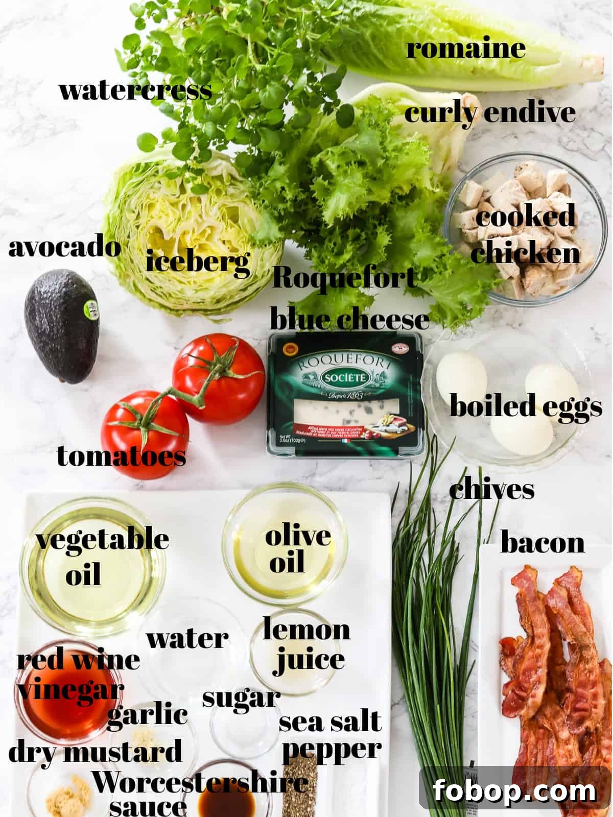 Classic Cobb Salad Recipe with Homemade Dressing and Tips 3 All the ingredients on a table listed to make Cobb Salad including lettuce, bacon and blue cheese.