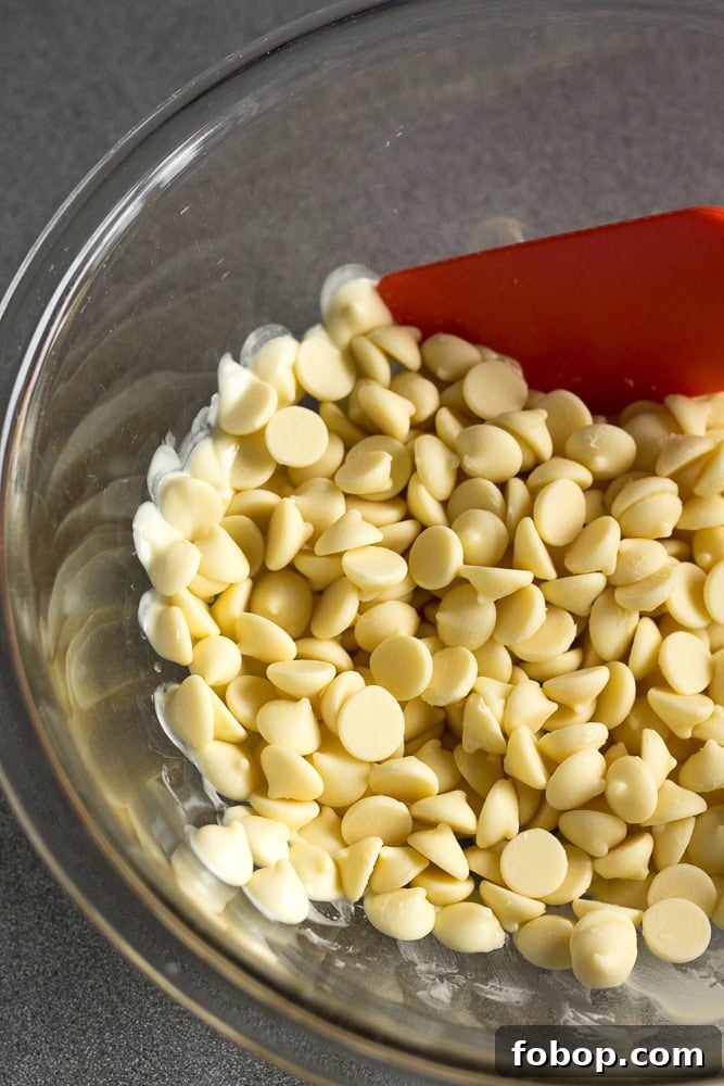 Gluten-Free White Chocolate Peppermint Bark Recipe 5 Partially melted white chocolate chips in a clear bowl.