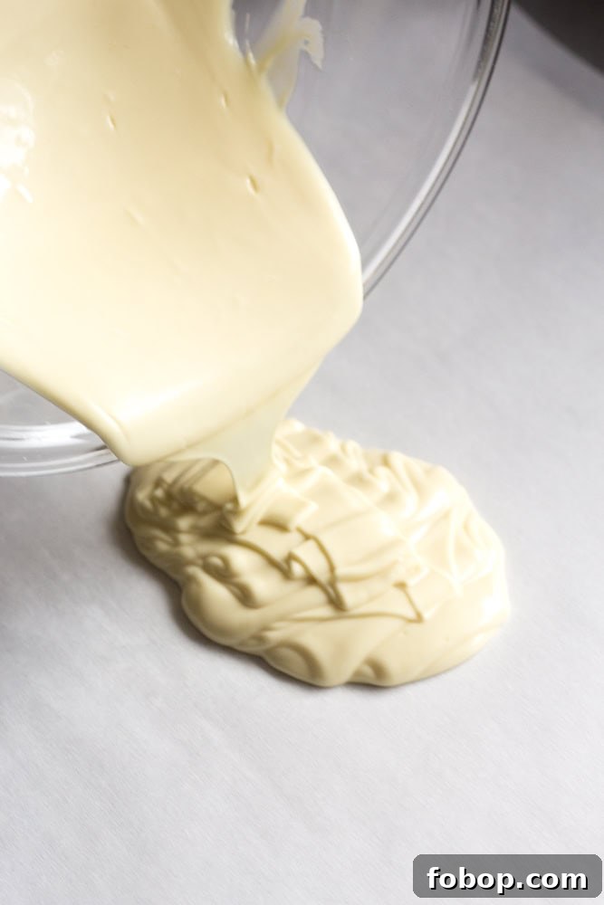 Gluten-Free White Chocolate Peppermint Bark Recipe 7 White chocolate being poured on parchment paper.