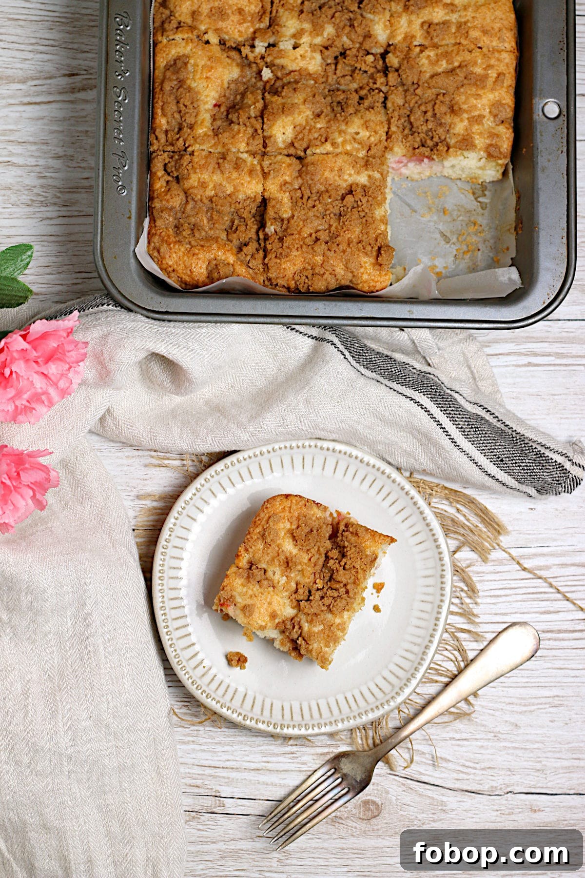 Moist Rhubarb Coffee Cake with Greek Yogurt 2 An overhead photo of a slice of Greek Yogurt Rhubarb Coffee Cake on a small white plate.