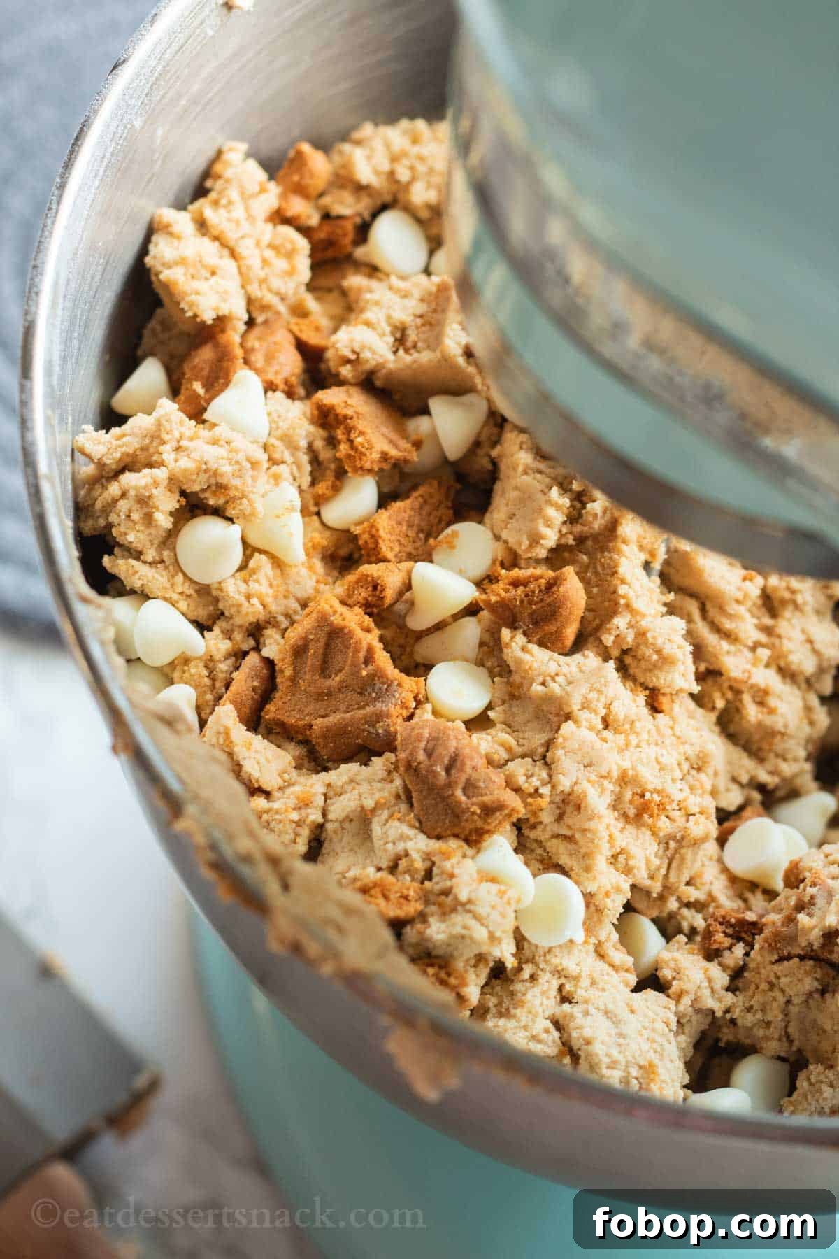 White Chocolate Biscoff Cookie Recipe: Crunchy Layered Cookies 7 Raw white chocoalte biscoff cookie dough in metal bowl of blue stand mixer.