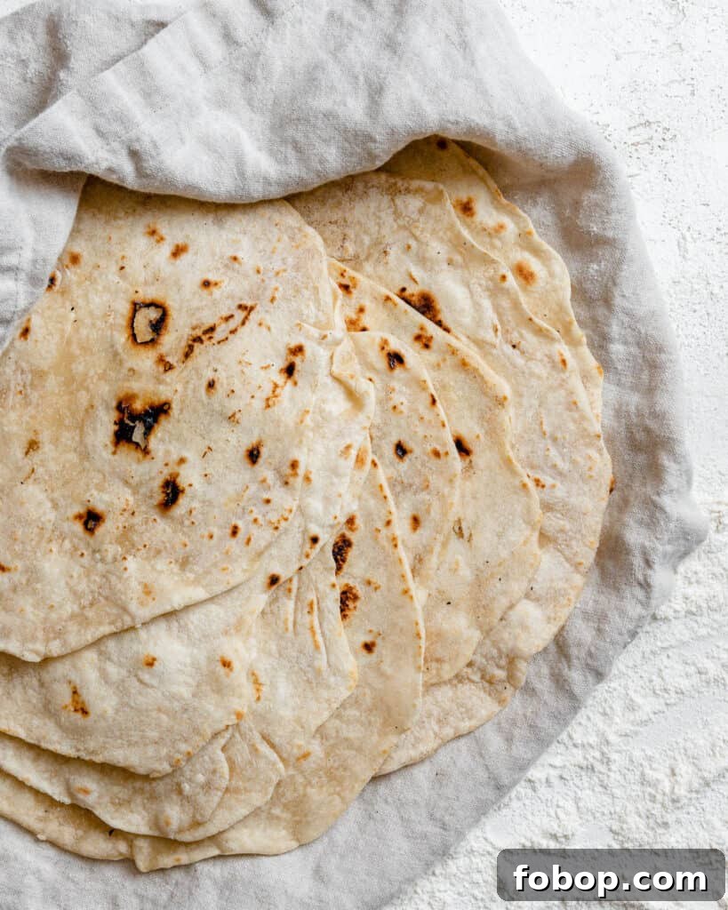 Handmade Flour Tortillas: Authentic Homemade Tortilla Recipe 15 completed Tortillas de Harina – Handmade Flour Tortillas stacked on one another against a white surface