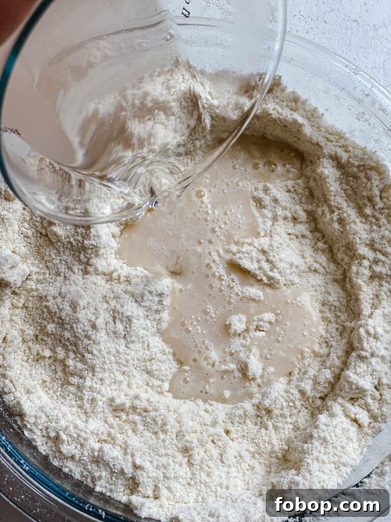 Handmade Flour Tortillas: Authentic Homemade Tortilla Recipe 7 process shot of adding liquid salt mixture to dry ingredients in bowl