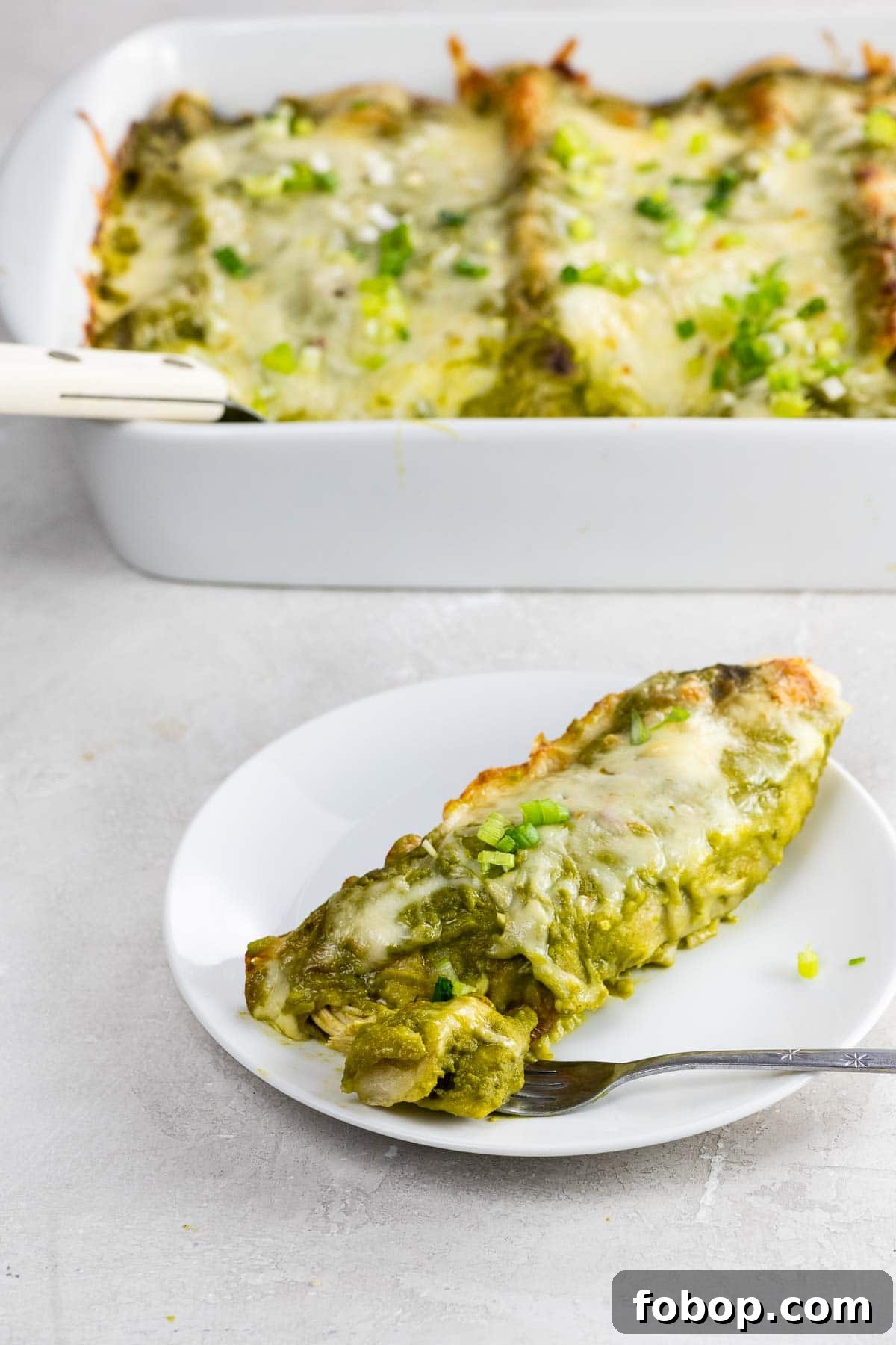 Authentic Green Enchilada Sauce Recipe for Flavorful Enchiladas 5 chicken and black bean enchiladas with green enchilada sauce in a pan and on a plate with a fork