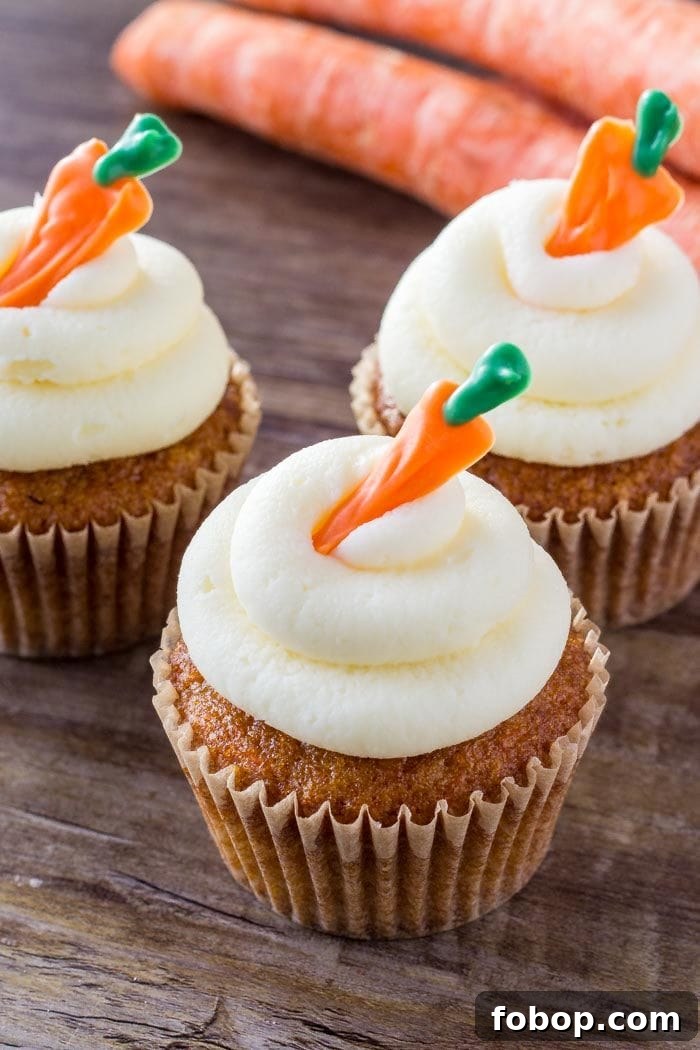 three carrot cake cupcakes on wooden surface