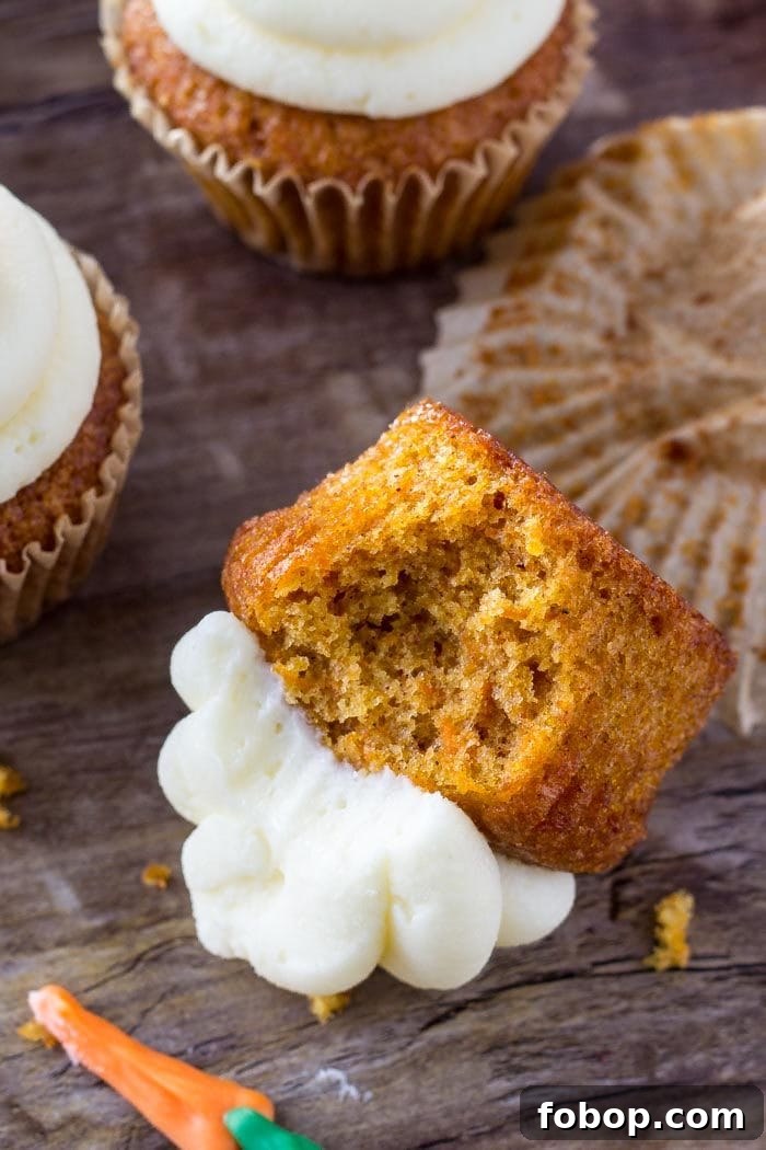 carrot cake cupcake with bite missing laying on its side
