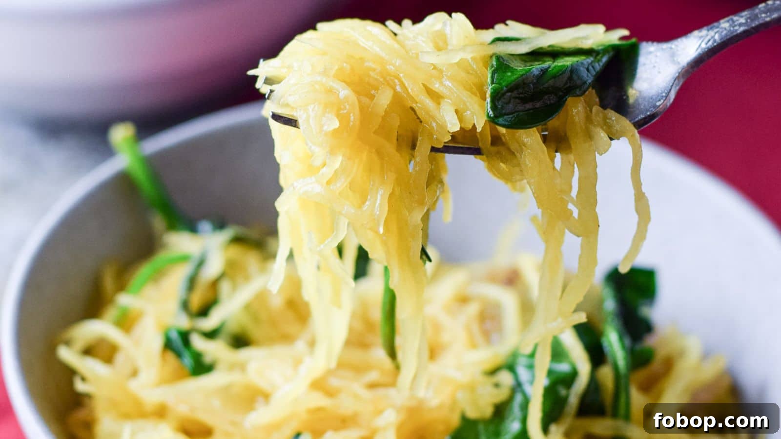 17 Flavor-Packed Side Dishes to Elevate Any Meal 11 A fork with spaghetti squash ad spinach on it held over the bowl