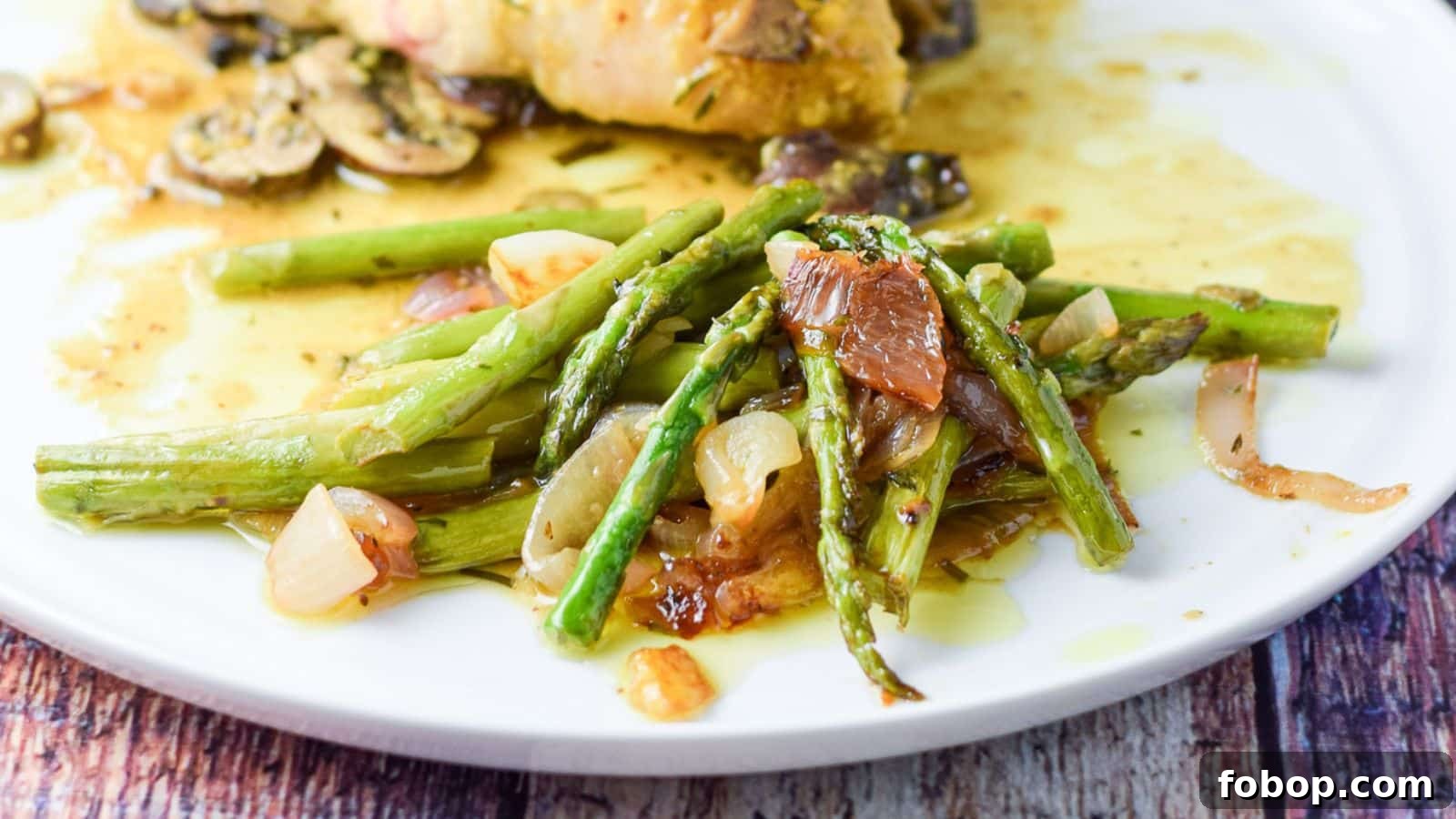 17 Flavor-Packed Side Dishes to Elevate Any Meal 15 A plate with asparagus and onions on it with chicken in the back