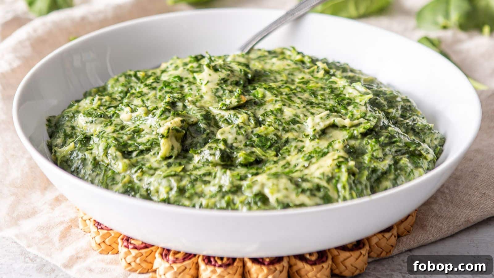 17 Flavor-Packed Side Dishes to Elevate Any Meal 10 A white deep bowl filled with the spinach with cream
