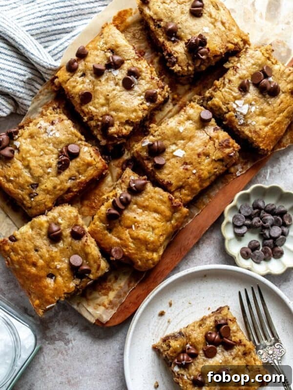 Peanut Butter Banana Bars on a cutting board with a plate on the side.