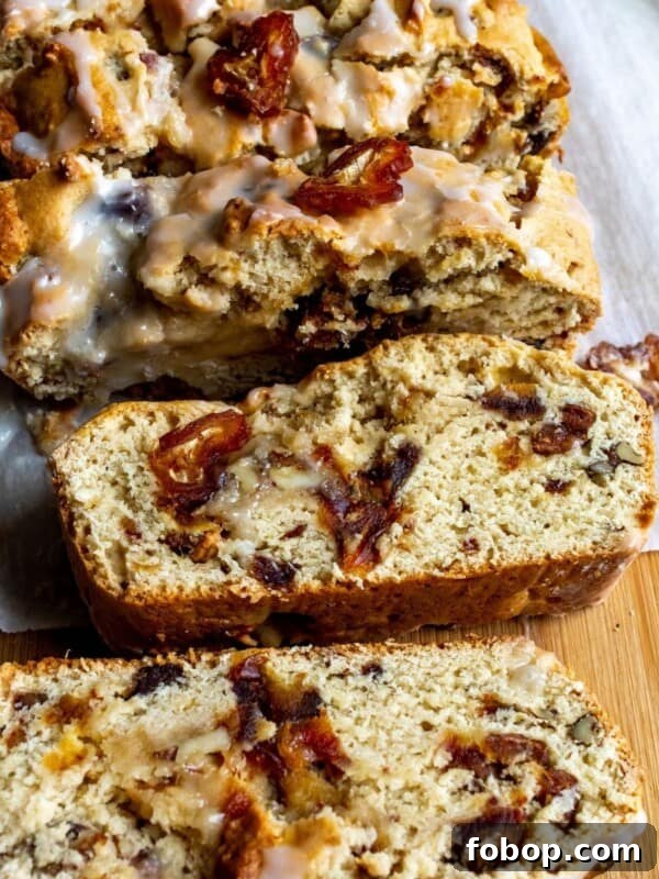Date nut bread on a cutting board with pieces standing up and some laying over.
