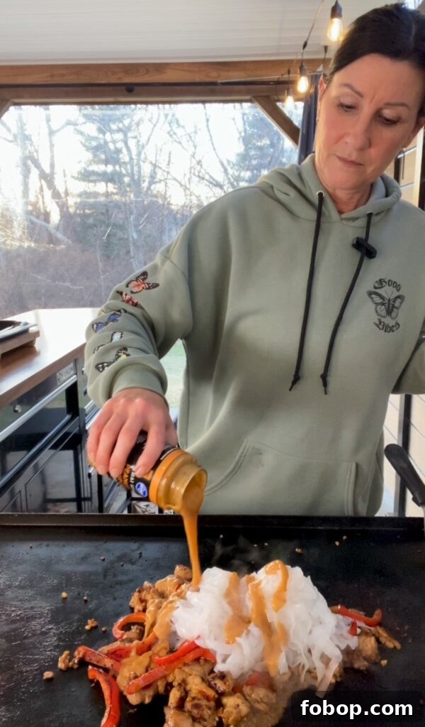 Low-Carb Peanut Chicken Noodles for Blackstone Grill 6 adding the sauce