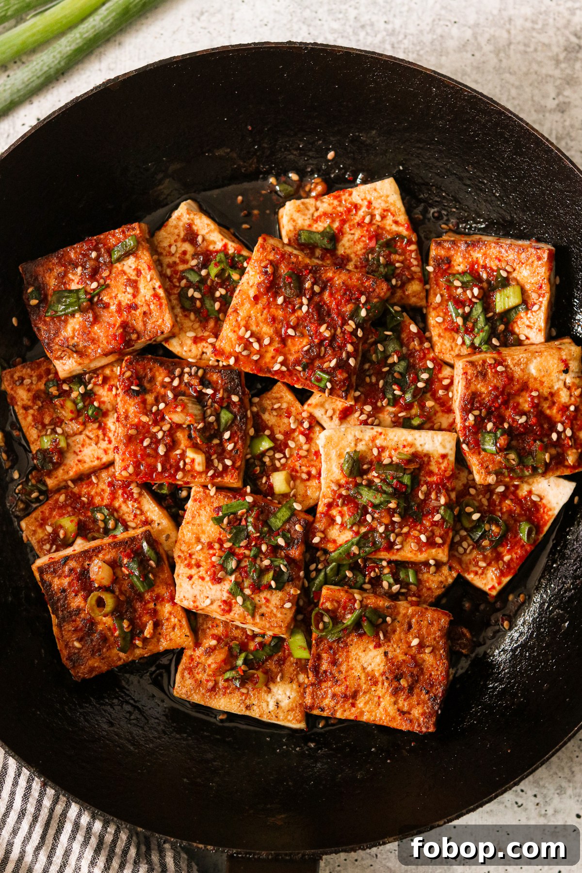a pan with tofu squares and braising sauce