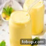 Mango milkshake garnished with mint leaves.