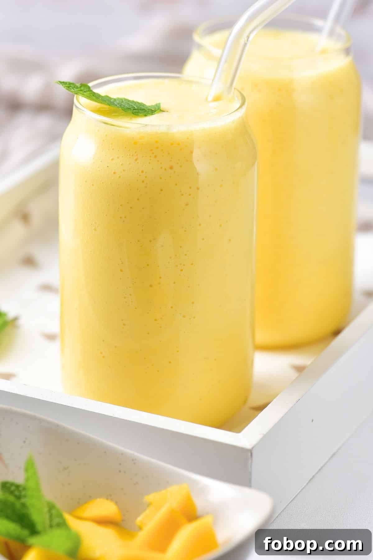 Up close shot of easy mango milk shake in glasses.
