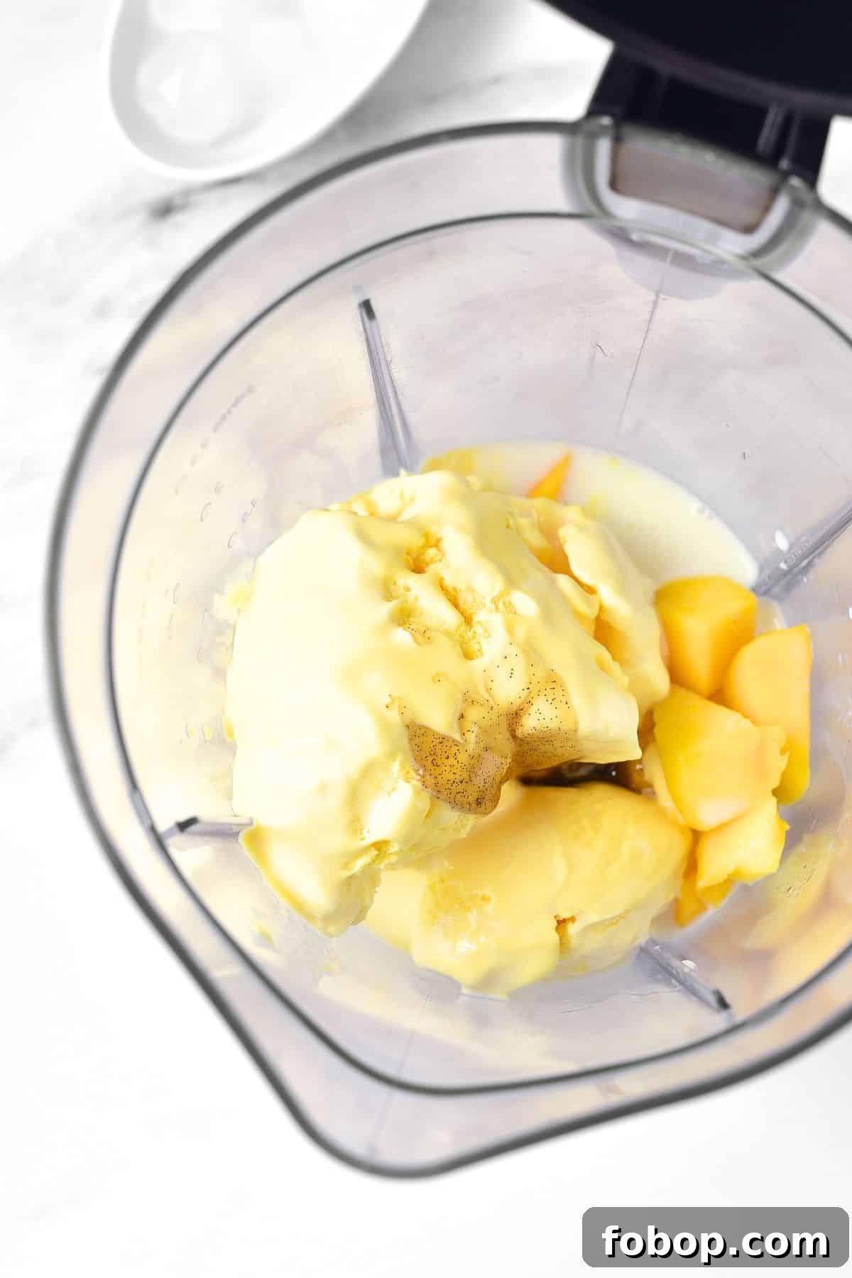 Ice cream, diced mango, milk, vanilla extract in blender.