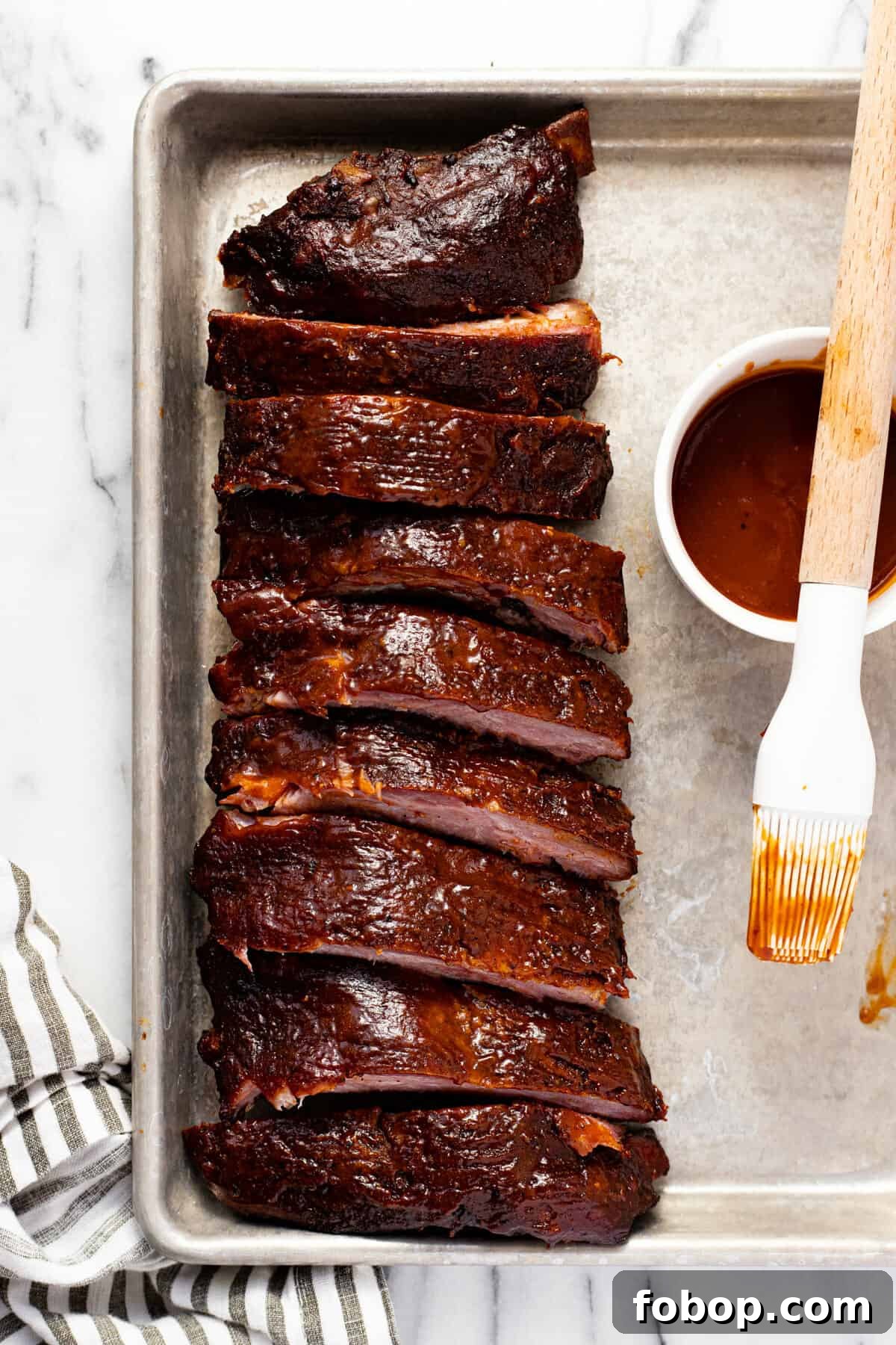 Smoked Baby Back Ribs: Tender, Flavorful Recipe for Beginners 2 Small sheet pan with smoked ribs and BBQ sauce on it.