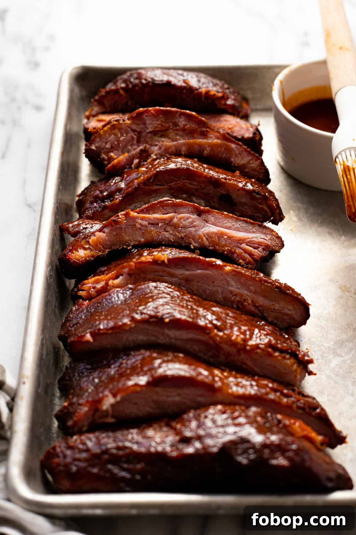 Smoked Baby Back Ribs: Tender, Flavorful Recipe for Beginners 11 Close up shot of sliced baby back ribs on a baking sheet.