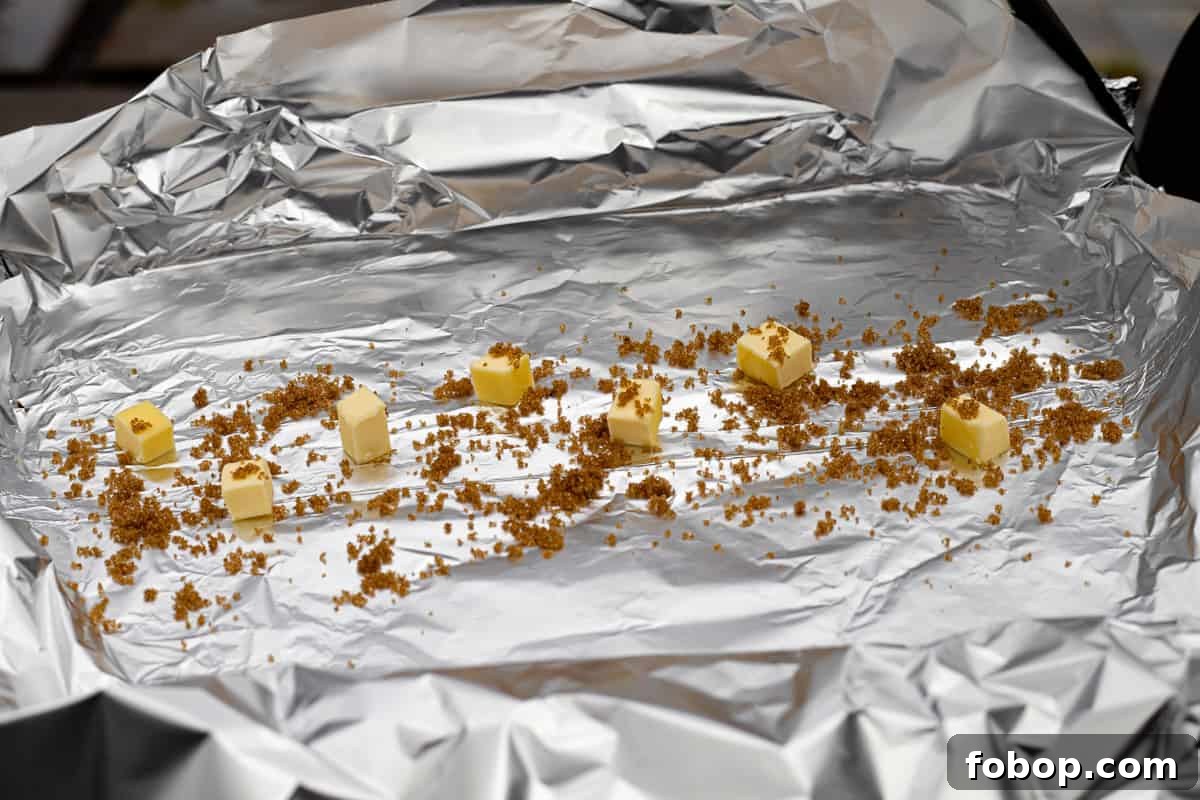 Smoked Baby Back Ribs: Tender, Flavorful Recipe for Beginners 7 Tin foil with cubes of butter and brown sugar.