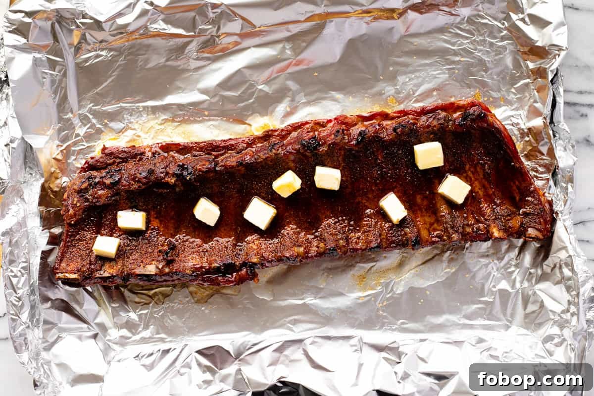 Smoked Baby Back Ribs: Tender, Flavorful Recipe for Beginners 8 Baby back ribs butter, brown sugar, and fruit juice on top.