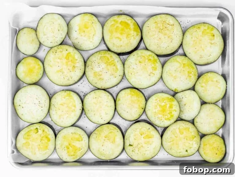 30 Delicious Eggplant Recipes for Every Meal 26 eggplant slices on a baking tray with parchment paper