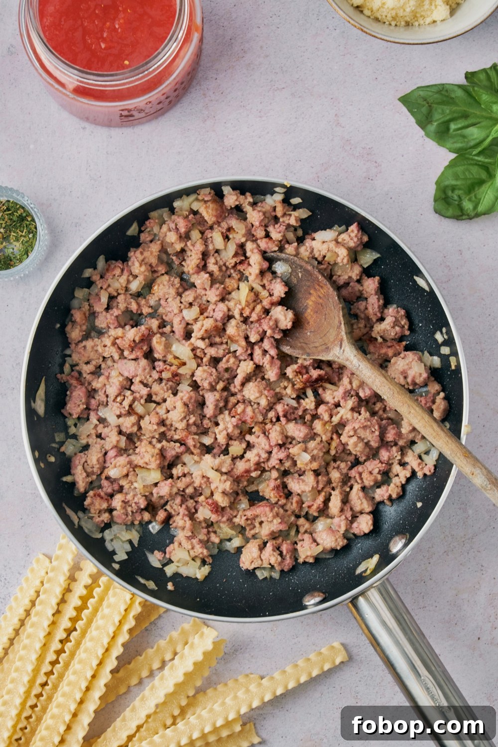 A skillet with ground beef cooking.