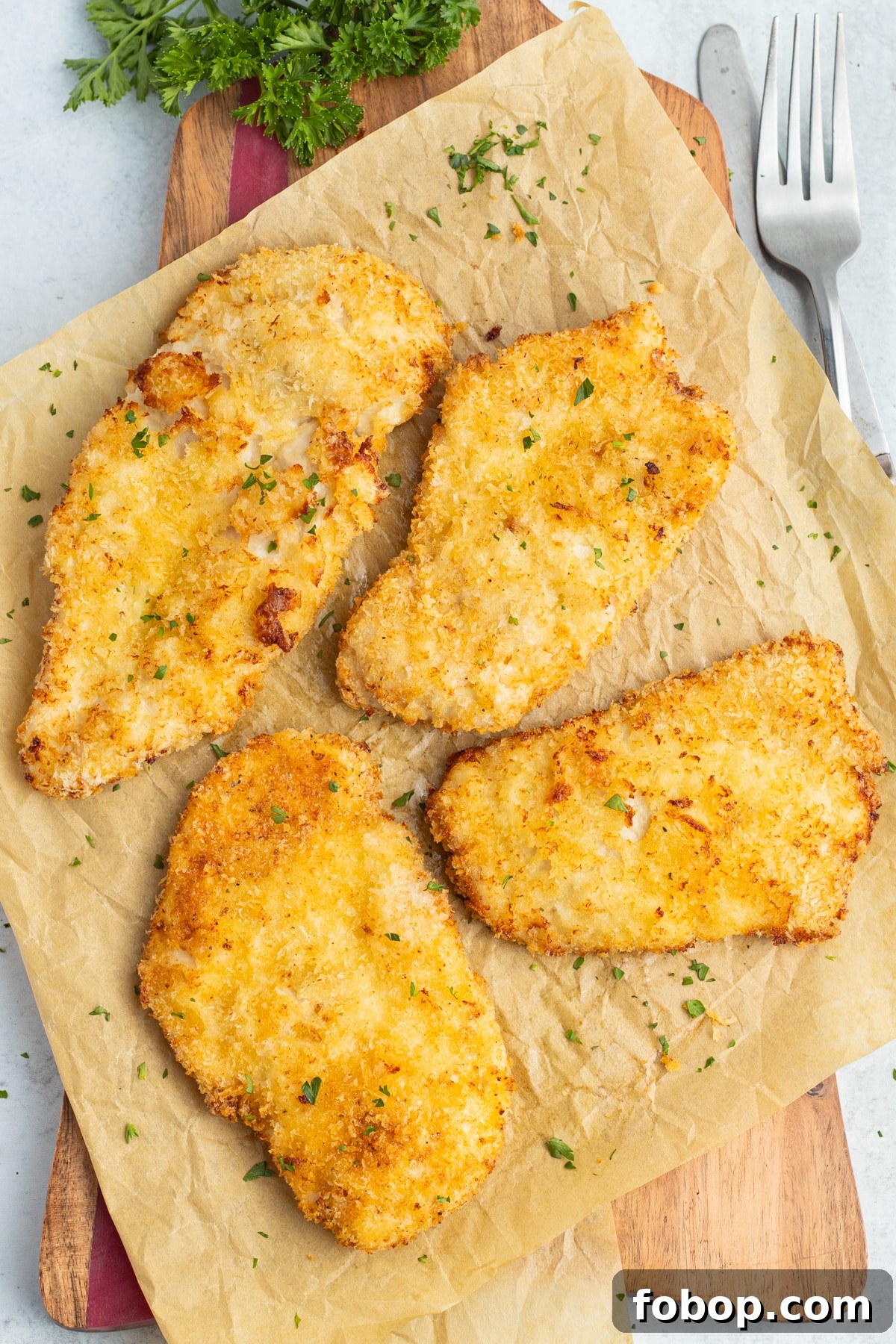 This is a picture of four air fryer chicken cutlets on a cutting board.