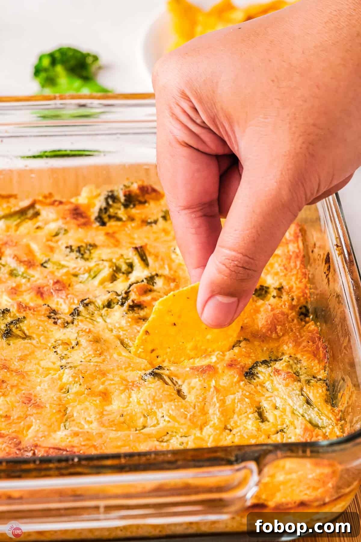 Creamy Broccoli Dip Recipe for Parties and Appetizers 9 hand with chip in hot dip