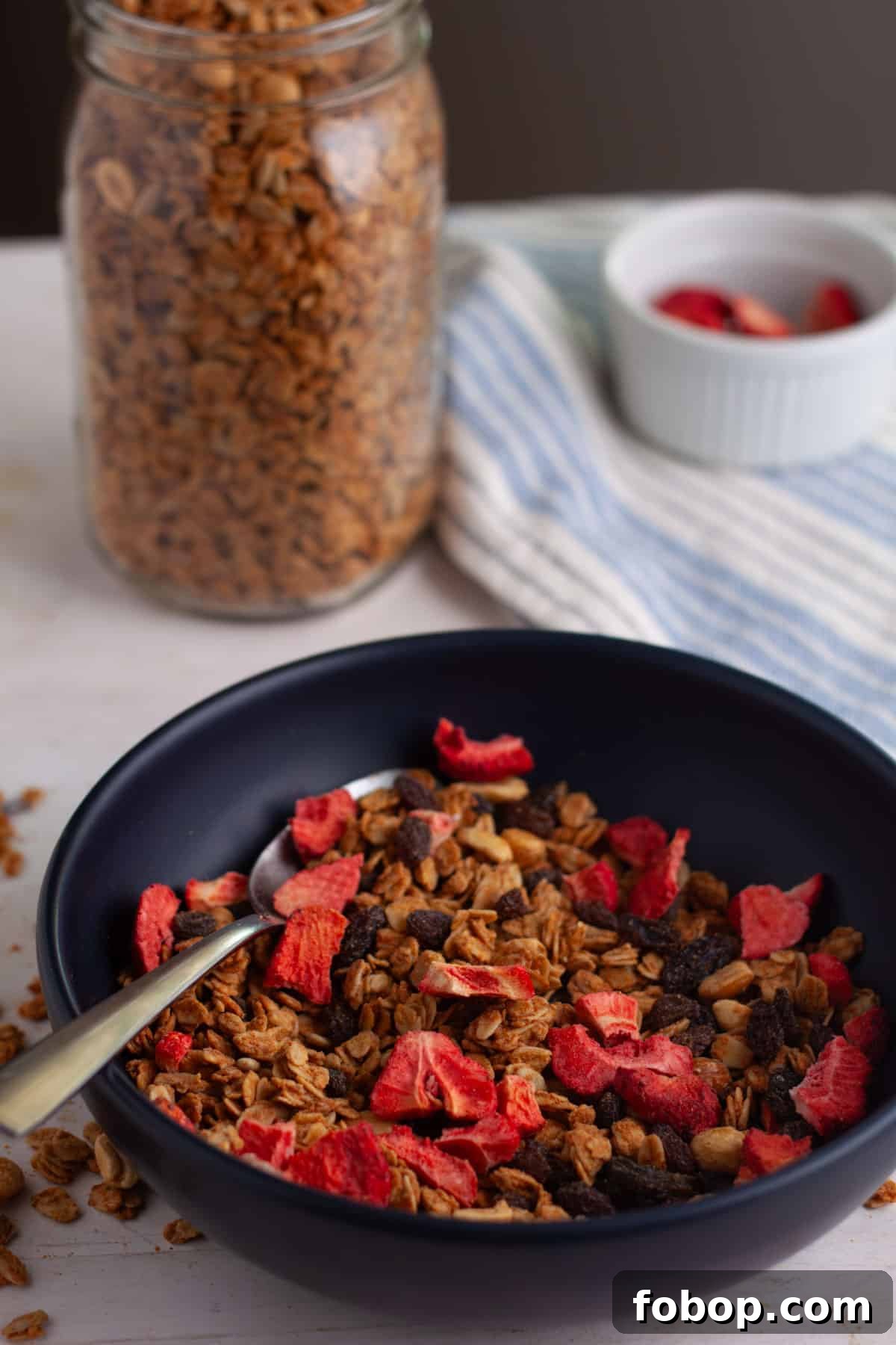 Crunchy Peanut Butter Granola Recipe for Homemade Snacks 10 homemade peanut butter granola in a bowl with dried strawberries.
