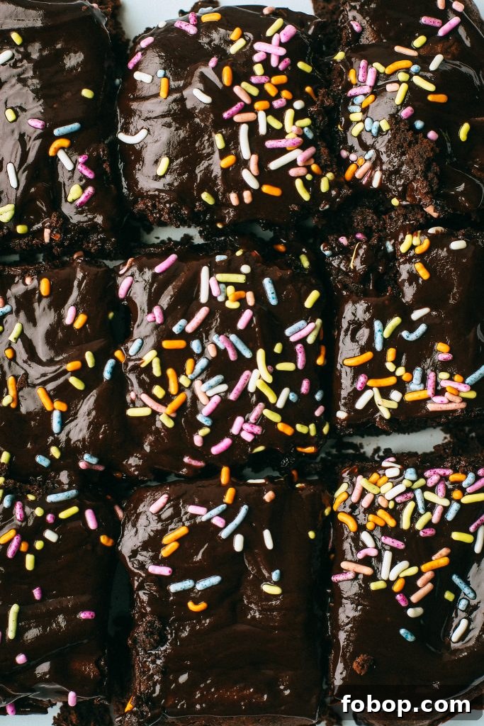 Gluten-Free Cosmic Brownies Recipe — Chewy Chocolate Treats 3 chocolate brownies with sprinkles on a white tray and wood cutting board with a pot of melted chocolate