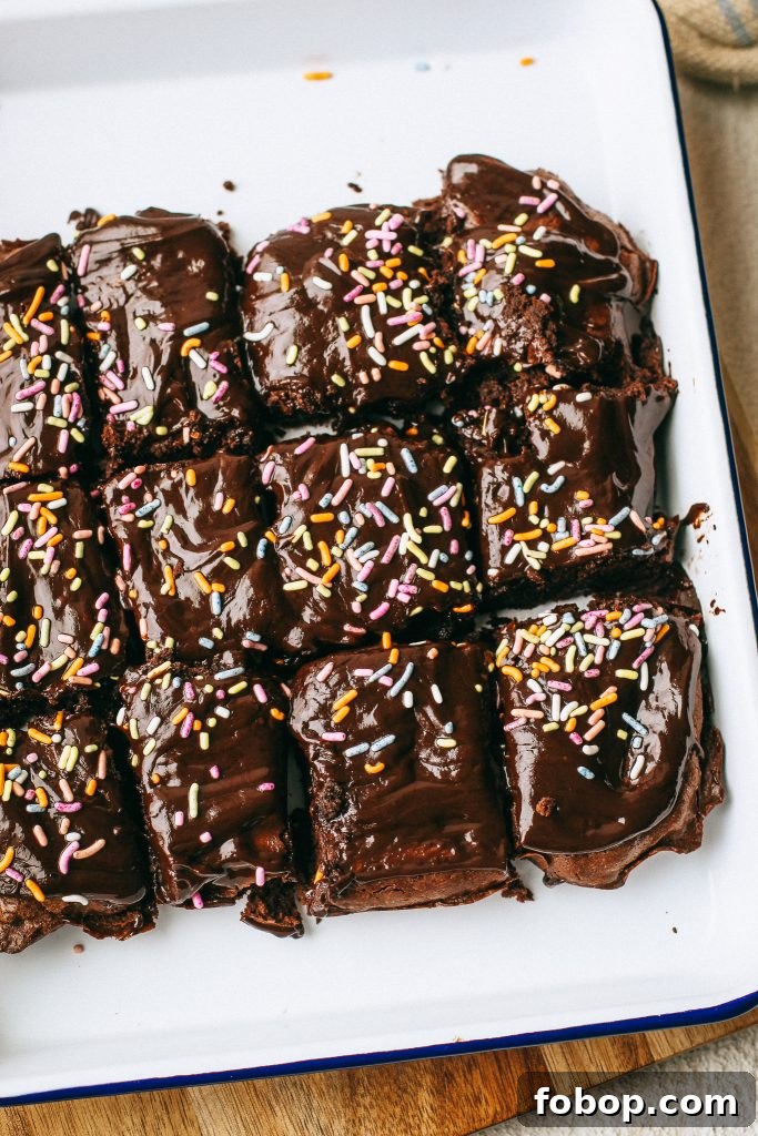 Gluten-Free Cosmic Brownies Recipe — Chewy Chocolate Treats 4 chocolate brownies with sprinkles on a white tray and wood cutting board with a pot of melted chocolate