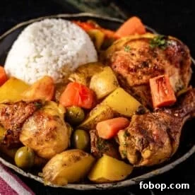 A bowl of pollo guisado chicken, carrots, potatoes, and a scoop or rice.