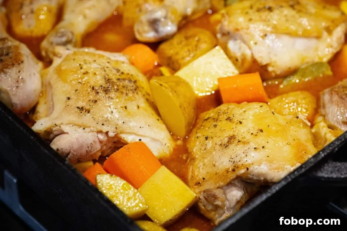 Chicken with chopped carrots and potatoes in a pot.