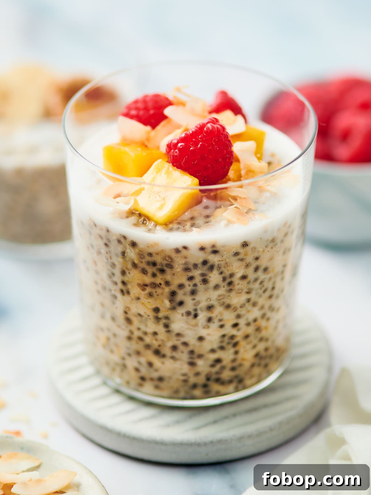 Overnight Oats with coconut milk in a glass jar topped with fruit.