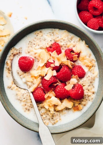 Bowl of Overnight Oats with Coconut Milk, topped with raspberries and coconut.