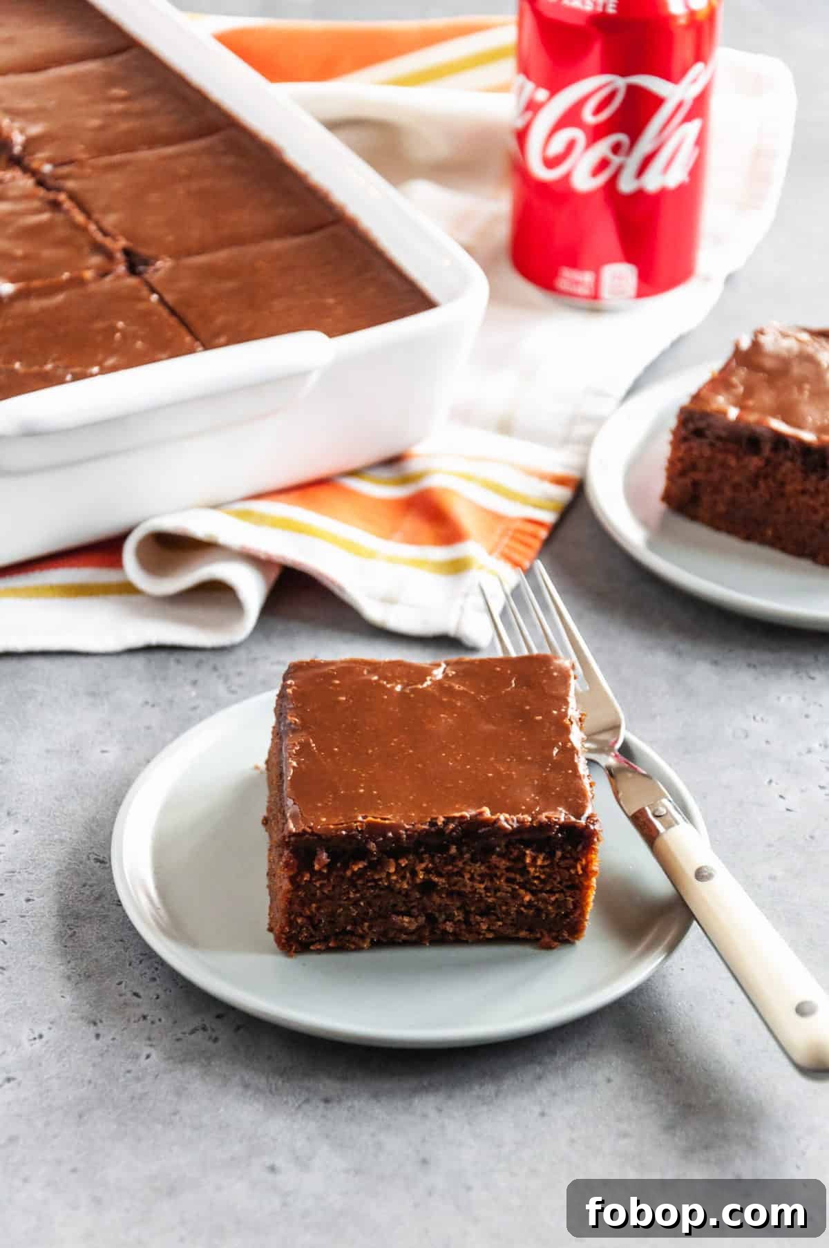 Moist Chocolate Coca-Cola Cake Recipe for Every Occasion 7 slice of coca cola cake on a round plate with a fork