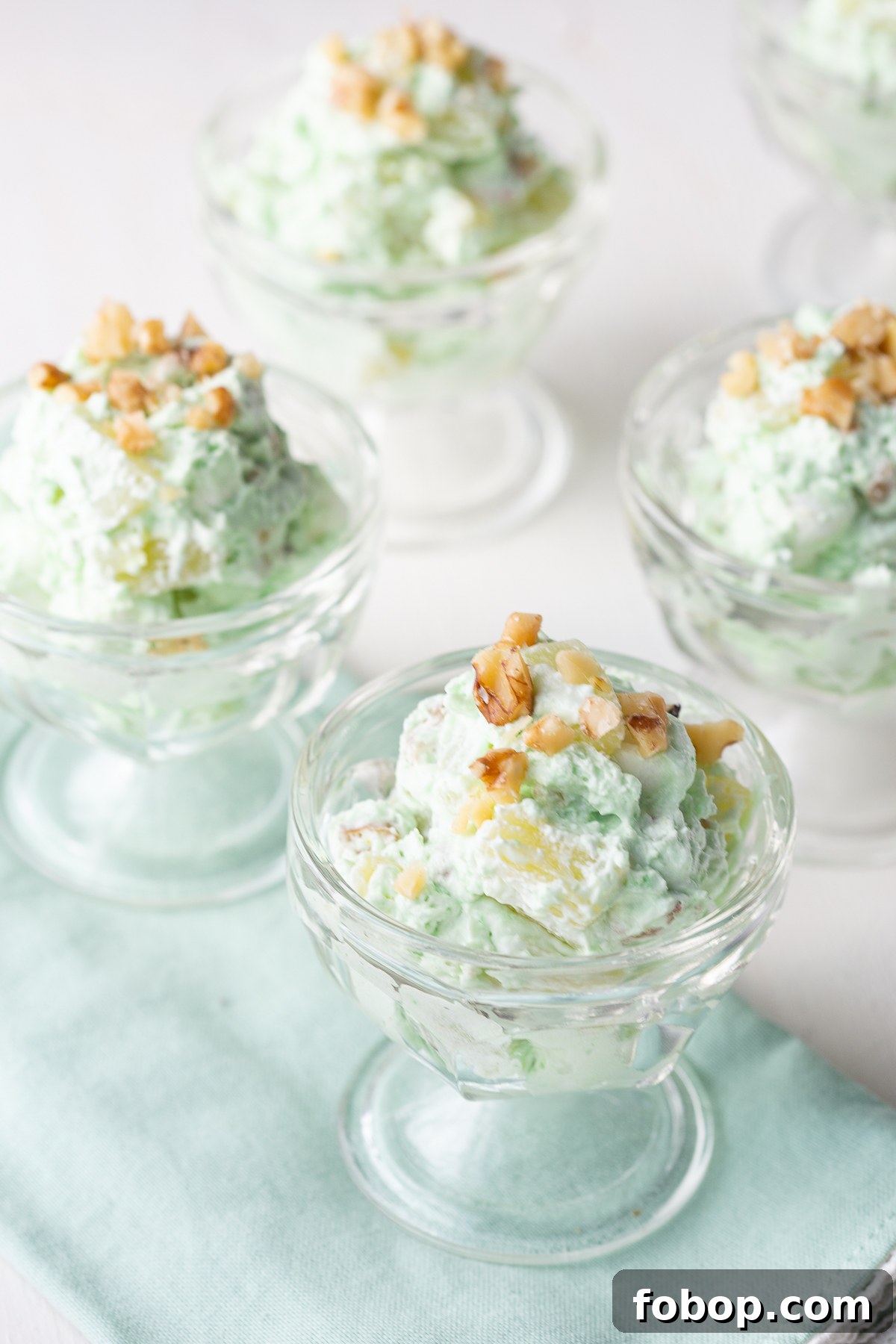 glass parfait glasses filled with pistachio salad, on a green napkin