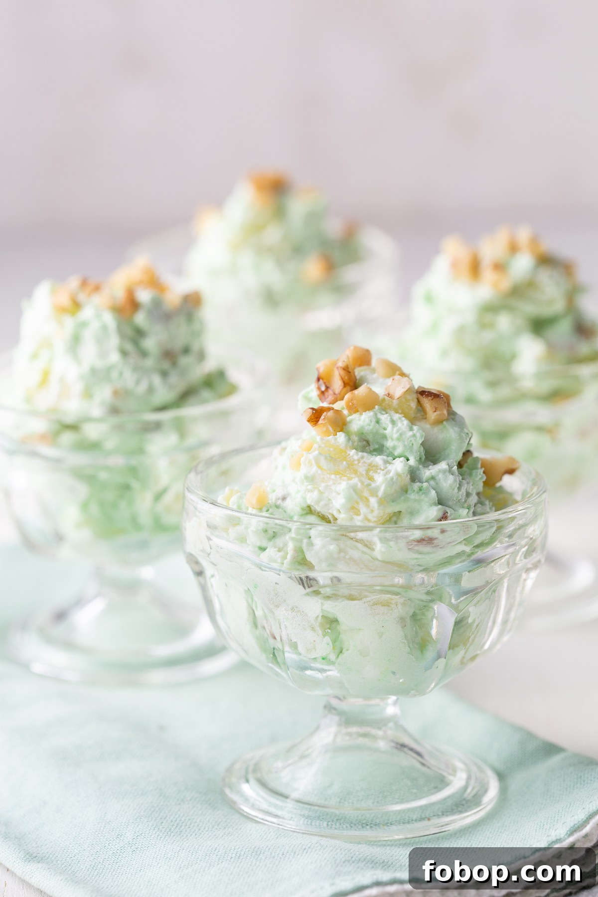 pistachio salad in mini parfait dishes, topped with chopped walnuts.