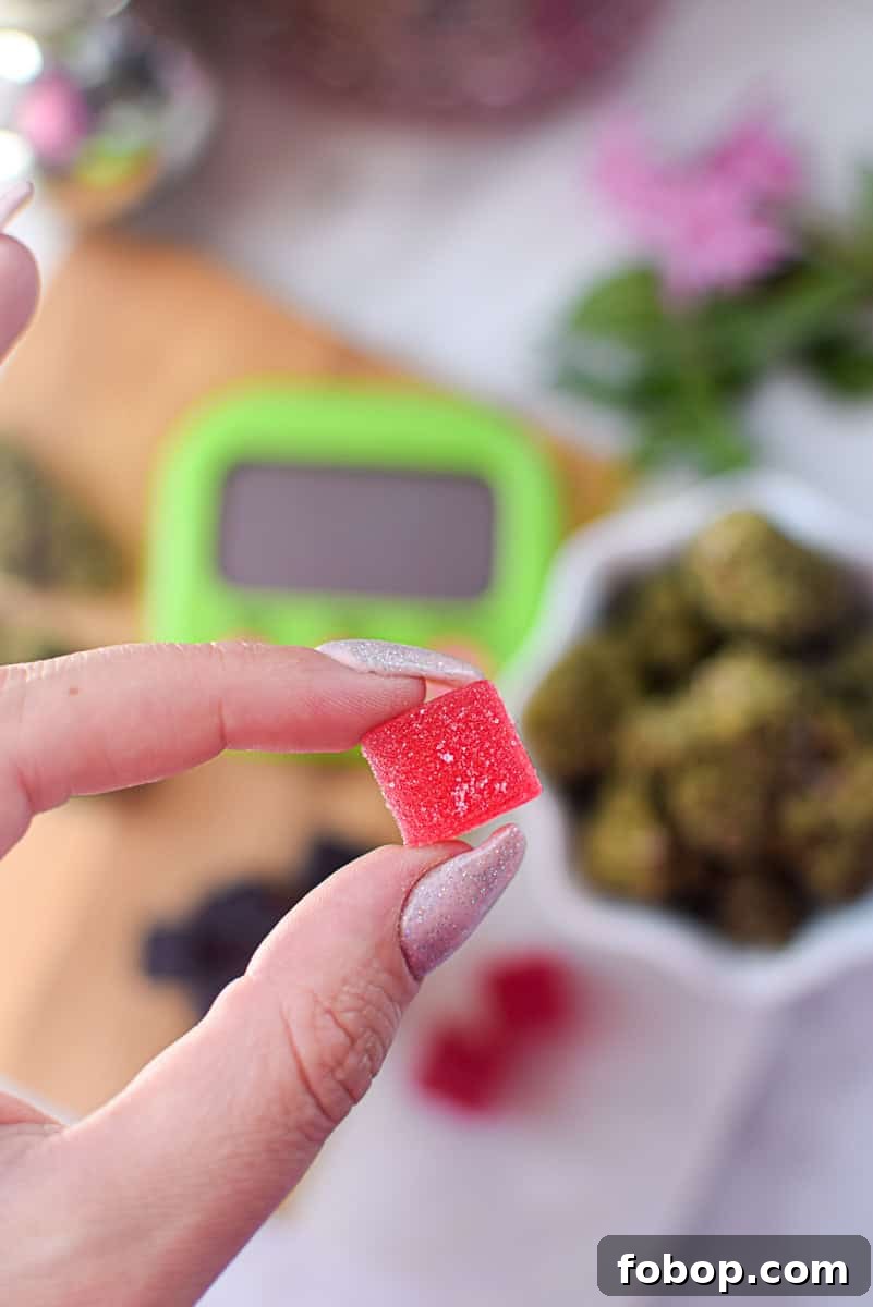 A picture of several different kinds of cannabis edibles, with a gummy in one hand. 