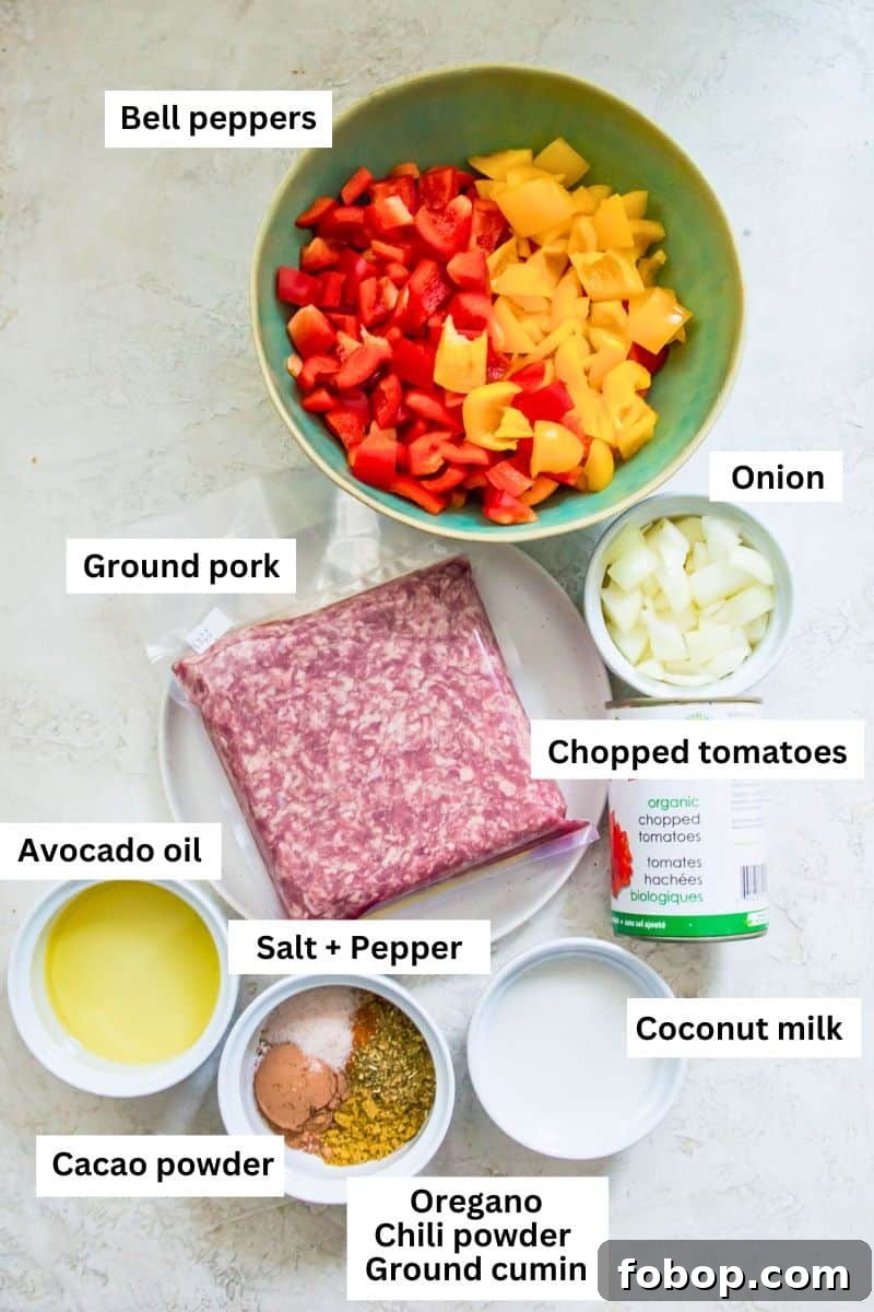 Ground Pork Chili Recipe Without Beans — Hearty Skillet Chili 3 The ingredient needed to make chili in separate bowls including bell peppers, onion, ground pork, tomatoes and spices.