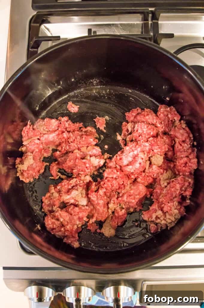 Ground Pork Chili Recipe Without Beans — Hearty Skillet Chili 5 Ground pork cooking in a pot on the stovetop.