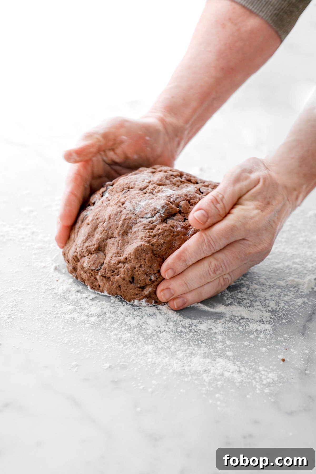 Double Chocolate Irish Stout Soda Bread Recipe for Rich Treat 8 chocolate dough being formed into a boule on floured marble surface.