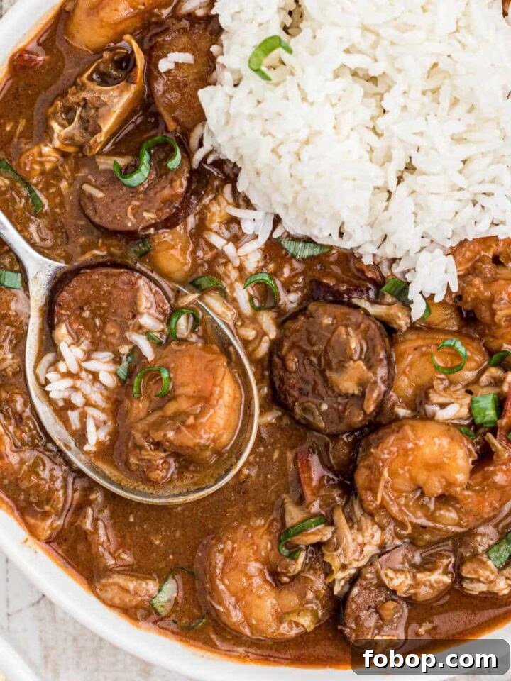 Authentic Homemade Creole Seasoning Recipe for Bold Flavor 6 Close up of a bowl of seafood gumbo with a pile of rice and a spoon digging into it.