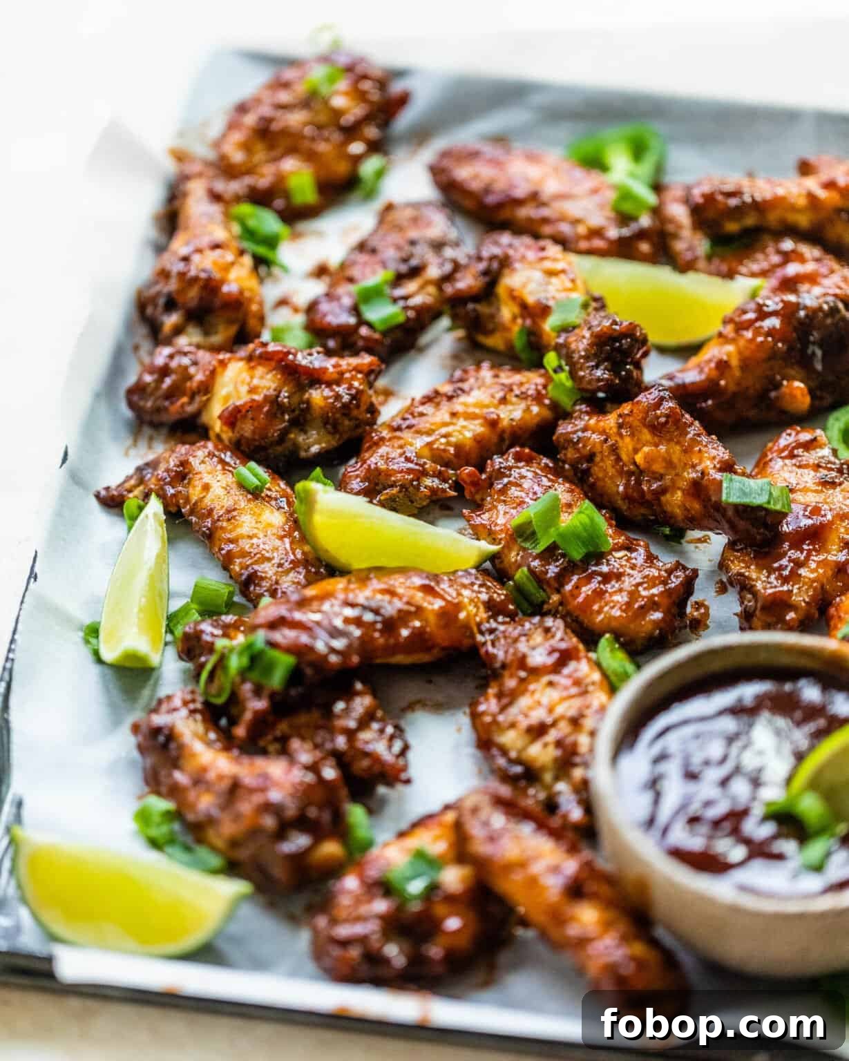 Crispy Cajun BBQ Oven Wings: Super Crunchy Baked Recipe 3 wings on a platter with bbq sauce and limes