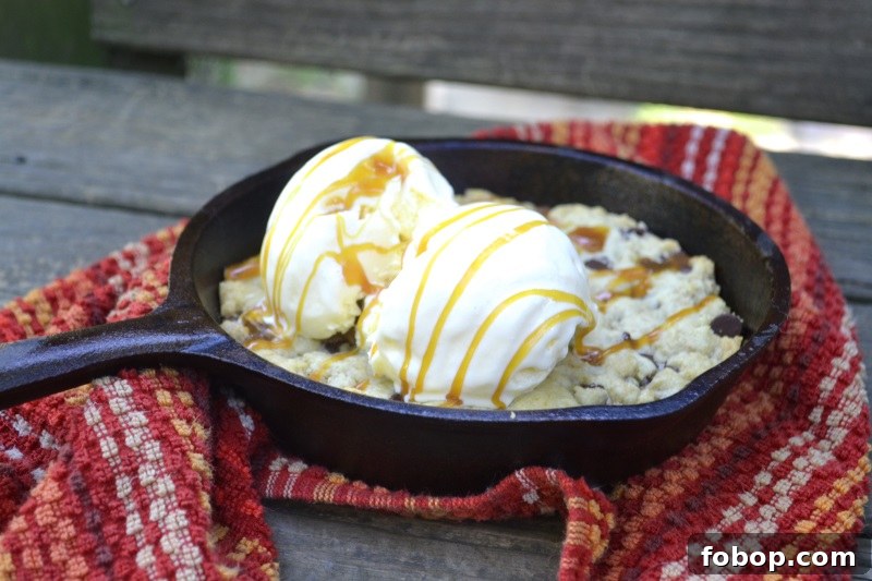 Chocolate Chip Skillet Cookie served with vanilla ice cream and caramel sauce in cast iron skillet from www.ApronFreeCooking.com