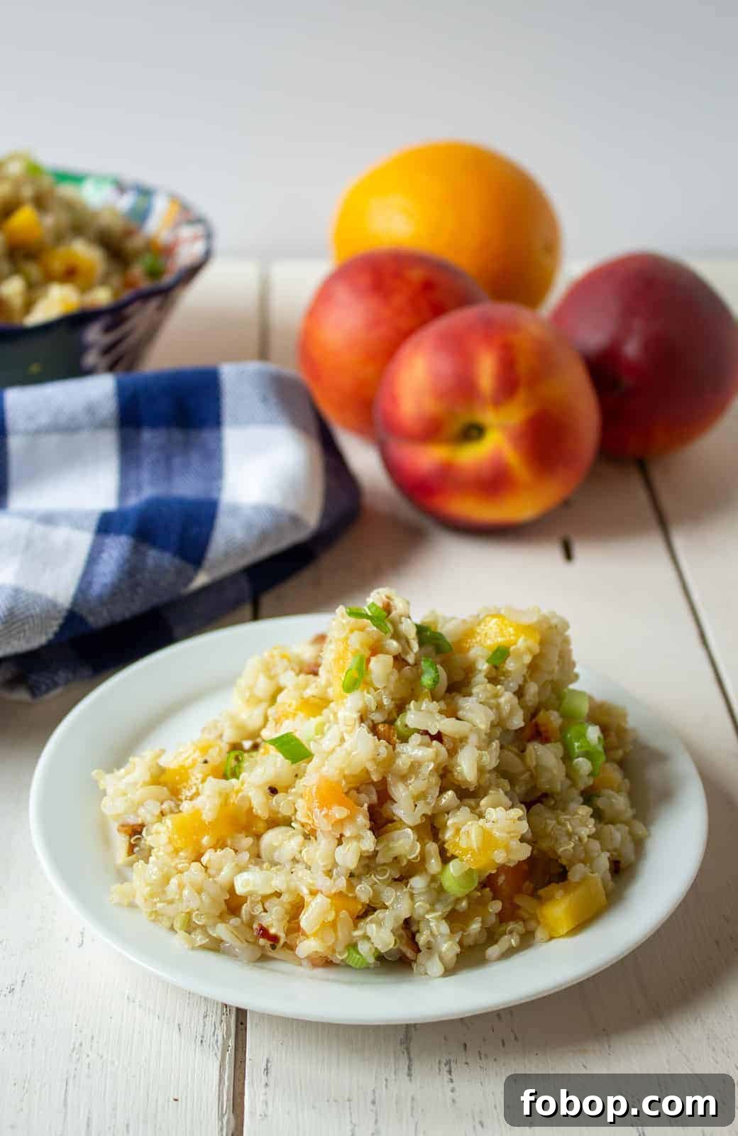 Quinoa peach salad on a small white plate.