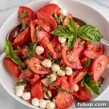 Tomato Basil Salad with mozzarella in a white bowl.