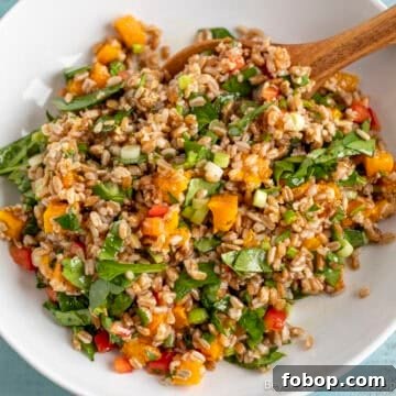 Farro Salad with roasted butternut squash and spinach in a white bowl.